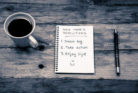 Top View 2019 New year resolutions list with plans for new life happy face written on notepad coffee and pen on Vintage table in Dreams and Goals for happiness Aspiration and Motivation Concept.の写真素材