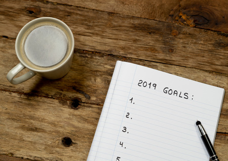 Top View 2019 Goals blank list for new New Year Resolution list on notepad coffee and pen on Vintage...