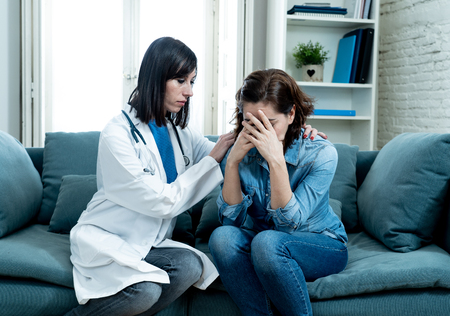 Female doctor comforting depressed crying woman patient sitting devastated at hospital private office after hearing serious disease diagnose or bad news in Health care support and trust concept.の写真素材