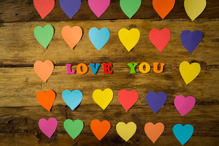 Colorful hearts and Love you message written with multicolor letters on wooden vintage background in Saint Valentines day theme decorations, greetings card design and love celebration concept.の写真素材