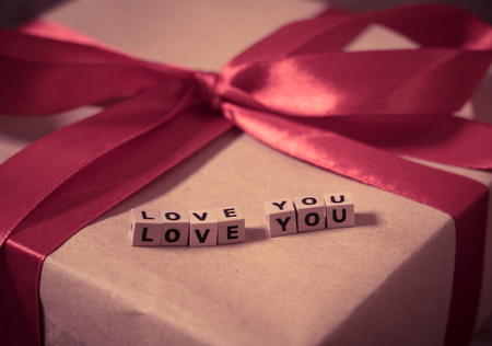 Close up of Love present gift with Love you message on wooden cubes in vintage style in Valentines...