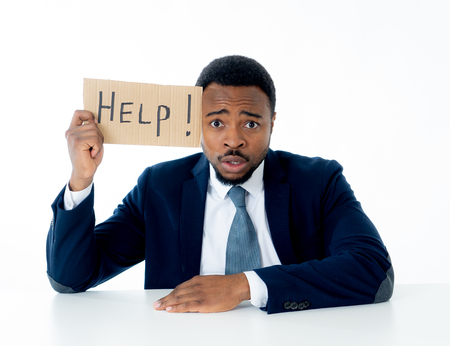 Young attractive and frustrated african american businessman holding message asking for help feeling sad and overworked in corporate job problem, business crisis and unemployment Depression concept.の写真素材