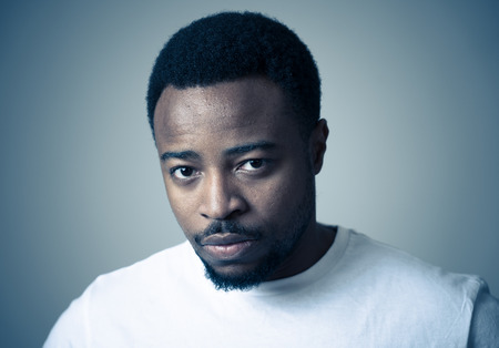 Portrait of african american adult in pain with sad and exhausted face looking concerned, worried and thoughtful in human emotions, facial expression and Depression. Isolated on neutral background.の写真素材