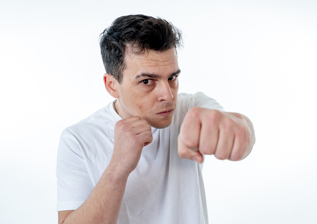 Close up portrait of an attractive young caucasian man with angry face looking furious and crazy showing teeth and fist isolated on white background. In People, Human facial expressions and emotions.の写真素材