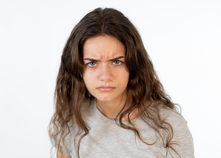 Close up portrait of a pretty young caucasian girl with an angry face. Looking outraged and mad...
