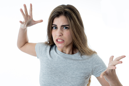 Close up of young attractive caucasian woman with an angry face. Looking mad and crazy shouting and making furious gestures. Isolated on white background. Facial expressions and emotions.の写真素材