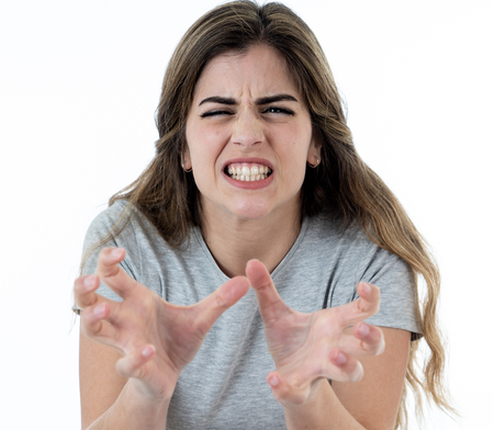 Close up of young attractive caucasian woman with an angry face. Looking mad and crazy shouting and making furious gestures. Isolated on white background. Facial expressions and emotions.の写真素材