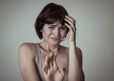 Portrait of young woman feeling scared and shocked making fear, anxiety gestures. Looking terrified...