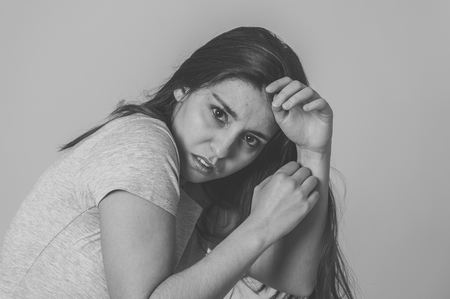 Black and white portrait of young woman feeling scared and shocked making fear, anxiety gestures. Looking terrified and covering herself. Copy space. In human expressions and emotions concept.の写真素材