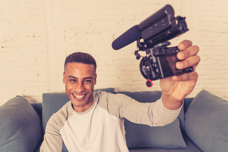 Life style portrait of young happy male blogger on camera screen filming a video tutorial for the...