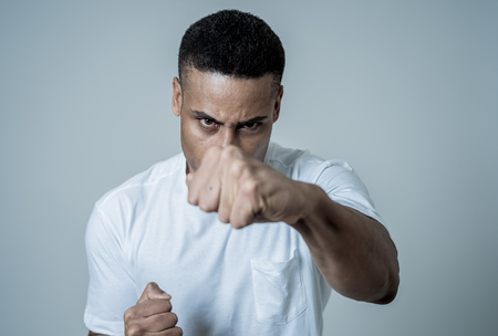 Close up portrait of an attractive young african american man with angry face looking furious and crazy having an argument or fight. In People, Human facial expressions and negative emotions.の写真素材