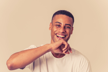 Portrait of happy african american man having fun and joy smiling at the camera and looking to something that makes him lough. In Human emotions facial expressions, happiness and beauty concept.の写真素材