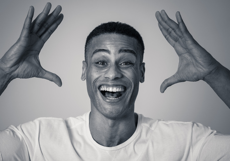 Portrait of Amazed excited african american Man achieving his goal or wining, laughing showing Victory gesture in Happy face facial expression, Human emotions happiness. Isolated on grey background.の写真素材