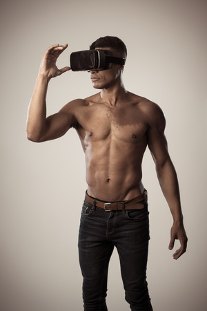 Attractive african american man using augmented VR glasses exploring 3d world feeling excited about simulation, new sensations and desires. In virtual reality, innovation and new technology concept.の写真素材