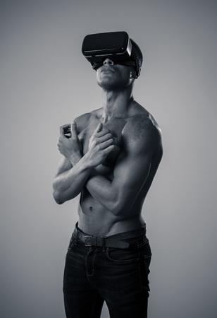 Attractive powerful african american man using augmented or VR goggles exploring new 3d world. Advertising of the power of virtual reality and augmented reality technology. 360 degree VR experiences.の写真素材