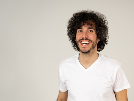 Portrait of attractive young model with happy face, beautiful smile and funny hair style. Handsome millennial man in his 20s. Studio shot. In People, fashion and human facial expressions and emotions.の写真素材