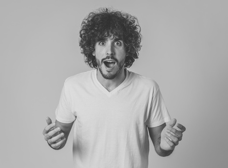 Portrait of funny attractive young man with happy and surprised face pointing and looking excited at something shocking and good. Human emotions, facial expressions. Advertising, sales or winning.の写真素材