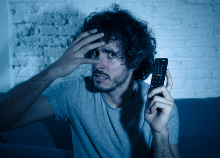 Lifestyle portrait of young man feeling scared and shocked making fear, anxiety gestures while...