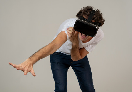 Amazed funny man using VR headset glasses touching and interacting with virtual reality world , feeling excited exploring and having fun in 360 VR simulation. Innovation and new technology concept.の写真素材