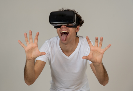 Amazed funny man using VR headset glasses touching and interacting with virtual reality world ,...