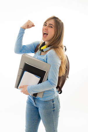 Beautiful millennial teenager girl with backpack and folder smiling and making happy and celebration gestures. Cheerful attractive student woman isolated on white background. In education and success.の写真素材