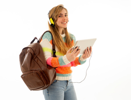 Portrait of happy young teenager student woman in headphones using tablet watching a video tutorial online curse or listening to music. Isolated white background. In technology and student lifestyle.の写真素材