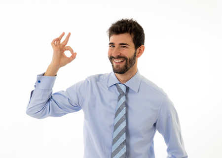 Half length portrait of young businessman standing and making all OK gesture. Smiling feeling confident and successful. In people business education, success and work environment concept. Studio shot.の写真素材