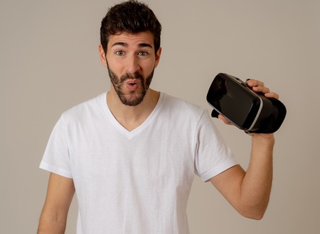 Virtual reality experience. Young caucasian bearded man happy to use VR goggles feeling excited about simulation and exploring virtual life. In New technology Virtual Augmented Reality concept.の写真素材