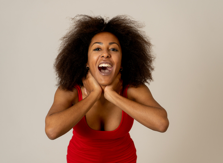 Happy portrait of beautiful young african american female laughing and enjoying life posing in red summer top. Image friendly for advertising. People fashion Human emotions and expressions.の写真素材