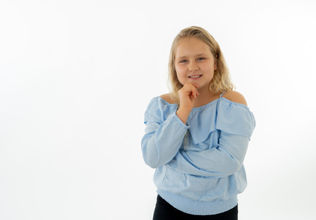 Close up portrait of a cute pretty child thinking and dreaming with her head resting on her hand. Isolated white background. Human emotions, facial expressions, body language and life perceptionの写真素材