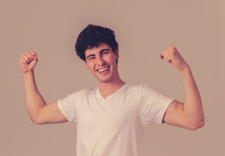 Portrait of young man celebrating achievement, a football goal, wining the lottery or having great success, shouting and gesturing in happiness. In face expression and Positive human emotions.の写真素材