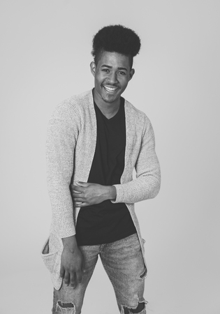 Portrait of attractive stylish young african american teenager man posing happy looking at the camera with fashion and stylish clothes and afro hairstyle. In People beauty and youth fashion trends.の写真素材