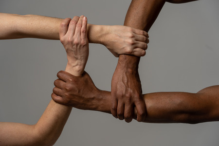 Races united against discrimination and racism. Black African American and Caucasian hands holding...