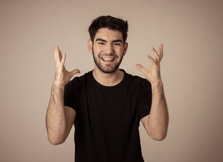 Portrait of young man celebrating achieving his goal, wining the lottery or having great success in face expression human emotions and surprised and happy facial expression isolated on grey.の写真素材