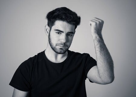 Young sad man suffering from depression looking serious and concerned. Teenager worried and thoughtful feeling lonely and hopeless Isolated on neutral background.People and mental health care.の写真素材