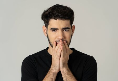 Young sad man suffering from depression looking serious and concerned. Teenager worried and...