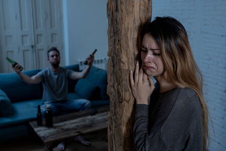 Social issues Domestic violence concept. Young couple having arguments and problems with alcoholic husband. Man threatening scared wife or girlfriend terrified of aggression and domestic abuse.の写真素材