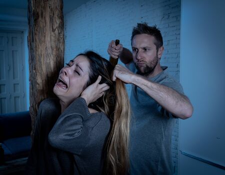 Social issues Domestic violence concept. Alcoholic and abuser partner beating and threatening his terrified wife. Violent man physically abusing scared girlfriend terrified of aggression and abuse.の写真素材