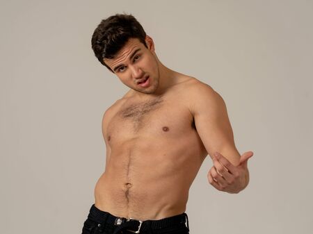 Portrait of sexy handsome Athletic man with strong torso posing manly for the camera. Studio shot of...