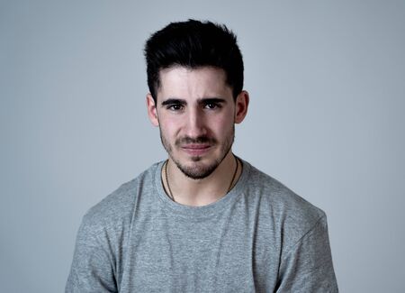 Close up portrait of sexy young man looking sad and stressed crying and feeling heartbroken. People facial expressions and emotions, depression, emotional pain and mental health in youth concept.の写真素材