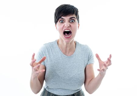Close up portrait of Young attractive caucasian woman with an angry face. Looking mad and crazy shouting and making furious gestures. Isolated on white background. Facial expressions and emotions.の写真素材