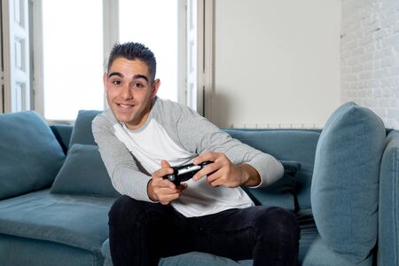 Portrait of young student man playing video games having fun winning the game using wireless remote...
