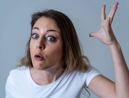 Close up portrait of young attractive caucasian woman with an angry face. Looking mad and crazy shouting and making furious gestures. Isolated on neutral background. Facial expressions and emotions.の写真素材