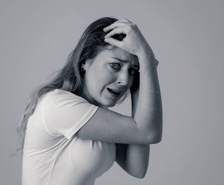 Close up of young woman feeling scared and shocked making fear, anxiety gestures. Looking terrified and desperate. People and Human expressions and emotions concept. Isolated on black and white.の写真素材