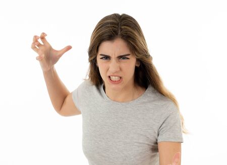 Close up of young attractive caucasian woman with an angry face. Looking mad and crazy shouting and making furious gestures. Isolated on white background. Facial expressions and emotions.の写真素材