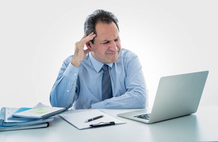 Angry and frustrated middle aged businessman overworked, upset and frustrated having too much work and staying extra hours at office. In Overtime, stress at work concept isolated in white background.の写真素材