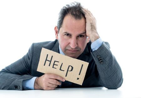 Depressed middle aged caucasian businessman desperate and tired holding a help sign looking...