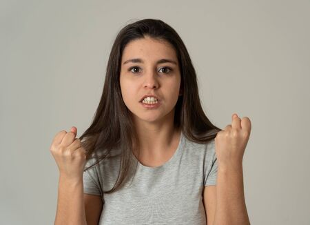 Close up of young attractive frustrated latin woman in stress with furious face. Looking mad and disappointed making angry gestures. In neutral background. In human facial expressions and emotions.の写真素材
