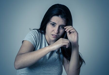 Young woman feeling scared and shocked making fear, anxiety gestures. Looking terrified and covering herself from an aggression. Copy space. People women domestic and gender violence victim concept.の写真素材