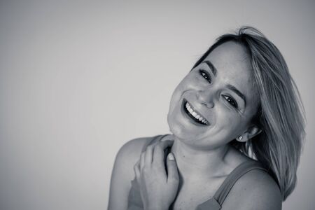 Close up black and white portrait of young beautiful caucasian woman with blond hair smiling, posing and modeling looking at the camera. Copy space. In People, lifestyle and beauty concept.の写真素材